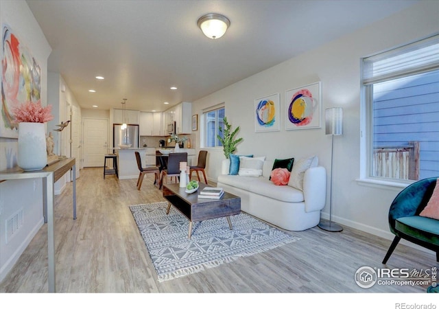 5863 Boston St, Denver, CO 80238 - living room featuring light wood-type flooring, baseboards, and recessed lighting
