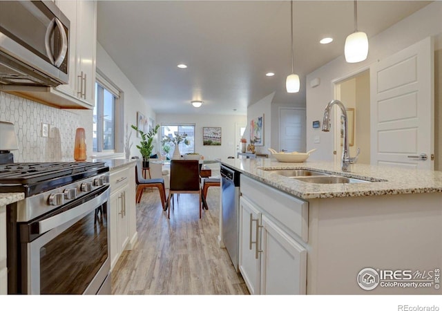 5863 Boston St, Denver, CO 80238 - kitchen with appliances with stainless steel finishes, a sink, recessed lighting, white cabinetry, and light wood-type flooring