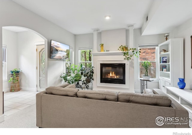 820 Kimbark St Unit D, Longmont, CO 80501 - carpeted living room with a glass covered fireplace, tile patterned flooring, arched walkways, and baseboards