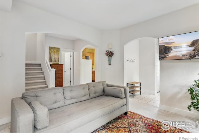 820 Kimbark St Unit D, Longmont, CO 80501 - living area featuring arched walkways, stairway, baseboards, and light colored carpet
