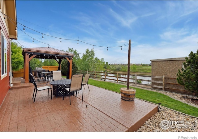 2767 Stallion Way, Mead, CO 80542 - fenced backyard featuring outdoor dining area, a patio, a gazebo, and a water view