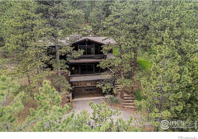335 Wild Horse Cir, Boulder, CO 80304 - rear view of property with a forest view, a balcony, stairs, and driveway