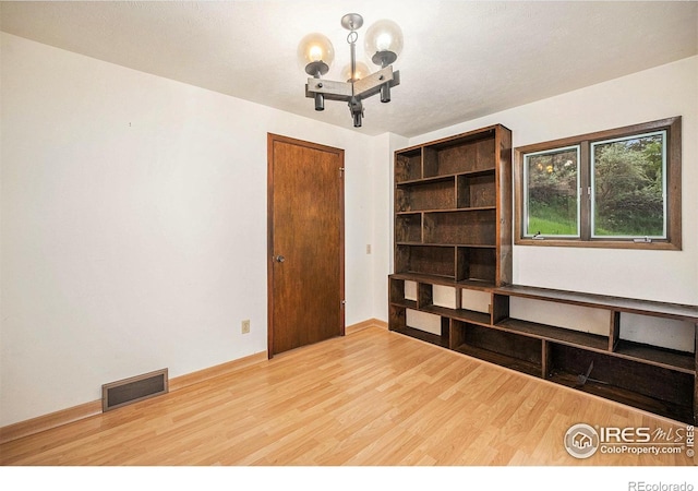 335 Wild Horse Cir, Boulder, CO 80304 - empty room with wood finished floors, a chandelier, and baseboards