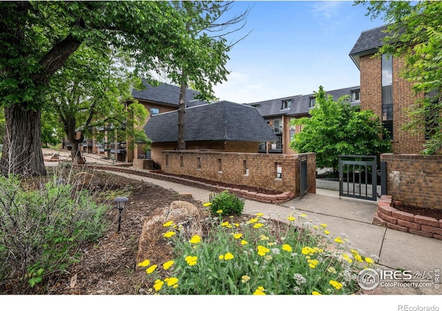1065 University Ave Unit 121, Boulder, CO 80302 - rear view of house featuring a gate, roof with shingles, and brick siding
