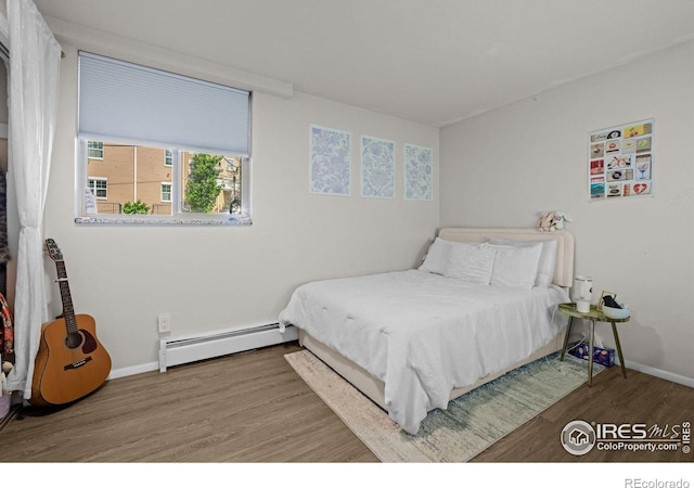1065 University Ave Unit 121, Boulder, CO 80302 - bedroom with baseboard heating, wood finished floors, and baseboards