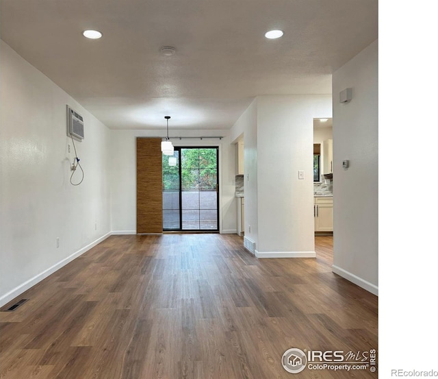 517 46th Ave, Greeley, CO 80634 - spare room featuring baseboards, dark wood-style flooring, an AC wall unit, and recessed lighting