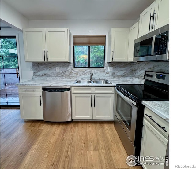 517 46th Ave, Greeley, CO 80634 - kitchen with stainless steel appliances, a sink, plenty of natural light, and light wood finished floors
