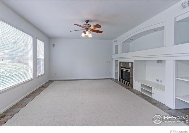 2631 E 136th Pl, Thornton, CO 80602 - unfurnished living room with built in features, a ceiling fan, a fireplace, and baseboards