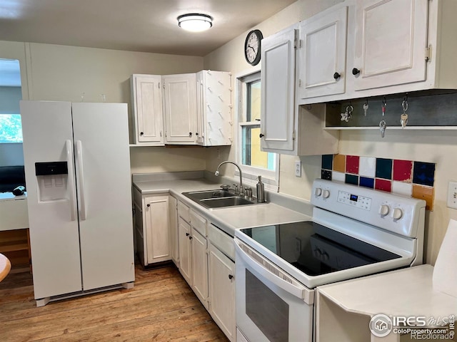 4501 Lawrence Ln, Laporte, CO 80535 - kitchen with white appliances, a sink, light wood-style flooring, white cabinets, and light countertops