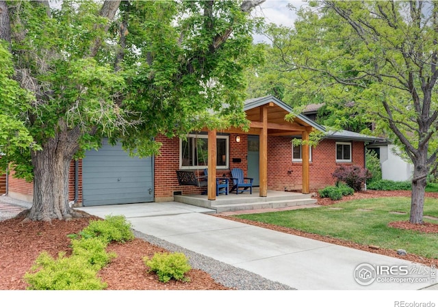 3445 Martin Dr, Boulder, CO 80305 - view of front of property with a porch, concrete driveway, an attached garage, brick siding, and a front yard