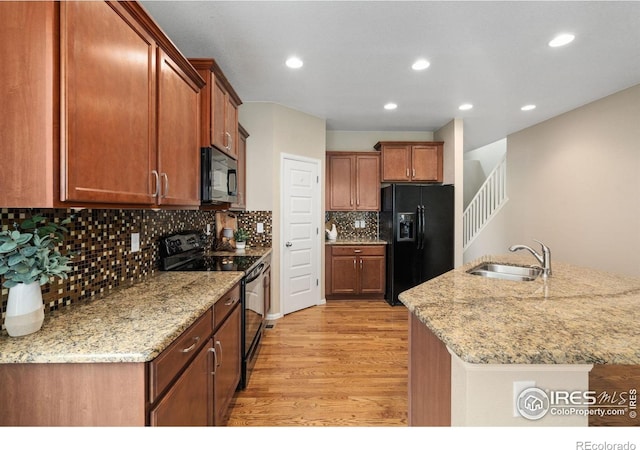 6340 Spring Valley Rd, Timnath, CO 80547 - kitchen featuring black appliances, a sink, light wood finished floors, tasteful backsplash, and light stone countertops