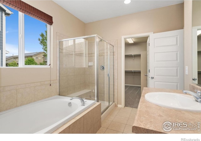 6340 Spring Valley Rd, Timnath, CO 80547 - full bathroom featuring a stall shower, a bath, tile patterned floors, vanity, and a walk in closet
