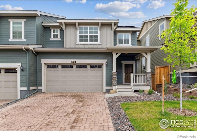 645 Flintwood Pl, Lafayette, CO 80026 - view of front of home featuring an attached garage, decorative driveway, board and batten siding, and a porch