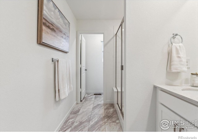 645 Flintwood Pl, Lafayette, CO 80026 - bathroom with marble finish flooring, a shower stall, vanity, and baseboards