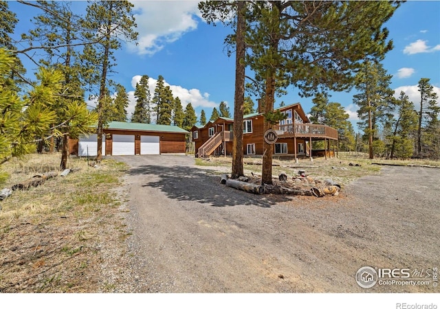 1954 Bluestem Way, Fairplay, CO 80440 - rustic home featuring a deck, an outdoor structure, a garage, stairs, and driveway