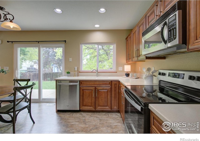 804 Nelson Park Ln, Longmont, CO 80503 - kitchen with stainless steel appliances, brown cabinets, a sink, recessed lighting, and light countertops