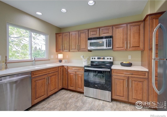 804 Nelson Park Ln, Longmont, CO 80503 - kitchen featuring stainless steel appliances, a sink, brown cabinetry, and recessed lighting