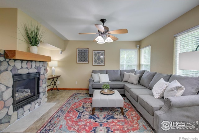 804 Nelson Park Ln, Longmont, CO 80503 - living room featuring plenty of natural light, ceiling fan, a stone fireplace, and baseboards