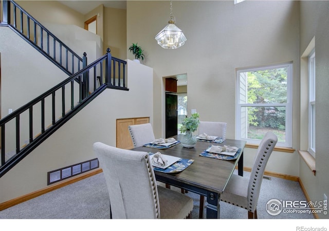 804 Nelson Park Ln, Longmont, CO 80503 - dining area with a high ceiling, stairs, a chandelier, carpet, and baseboards