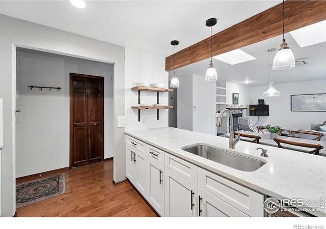 3255 34th St Unit 42, Boulder, CO 80301 - kitchen featuring a sink, light wood-style flooring, light stone counters, white cabinets, and pendant lighting