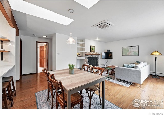 3255 34th St Unit 42, Boulder, CO 80301 - dining room featuring a skylight, wood finished floors, a glass covered fireplace, and a baseboard heating unit