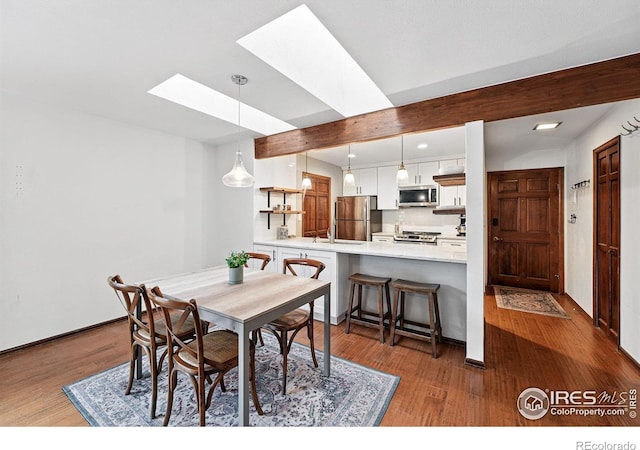 3255 34th St Unit 42, Boulder, CO 80301 - dining space featuring a skylight, wood finished floors, baseboards, and recessed lighting