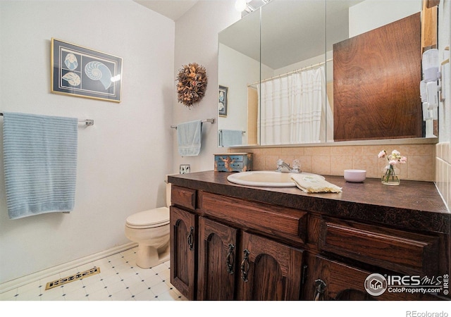 1702 Kennedy Ave, Loveland, CO 80538 - bathroom with vanity, toilet, tile patterned floors, baseboards, and a shower with curtain