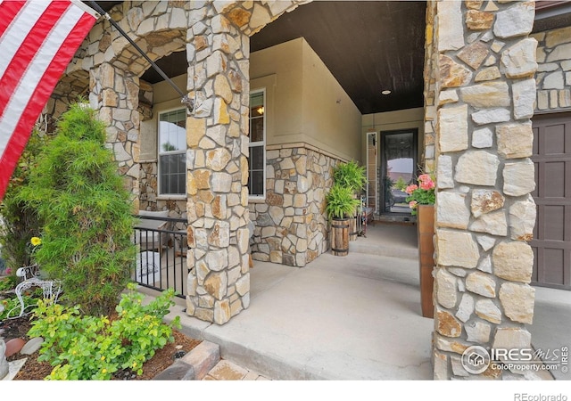 2038 Vineyard Dr, Windsor, CO 80550 - view of exterior entry featuring stone siding and a porch