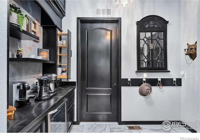 2038 Vineyard Dr, Windsor, CO 80550 - kitchen with dark countertops, light marble finish flooring, open shelves, and dark cabinetry