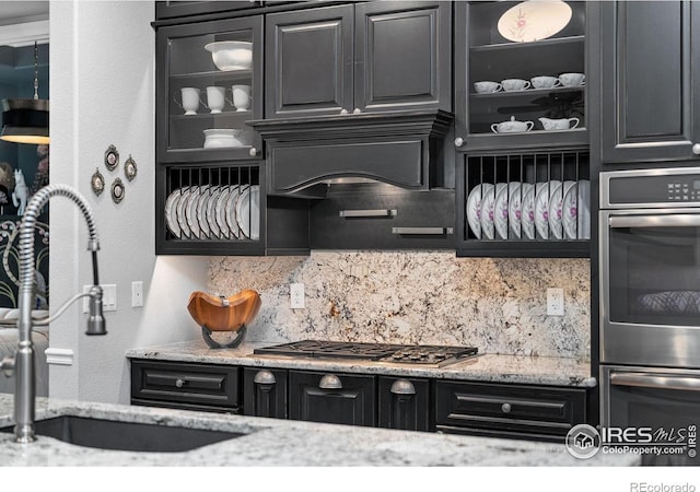 2038 Vineyard Dr, Windsor, CO 80550 - kitchen featuring a sink, decorative backsplash, glass insert cabinets, and stainless steel appliances