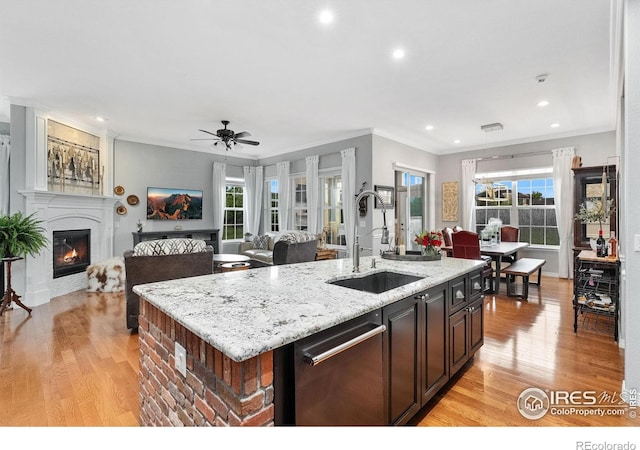 2038 Vineyard Dr, Windsor, CO 80550 - kitchen with a sink, dishwasher, crown molding, light wood finished floors, and a kitchen island with sink