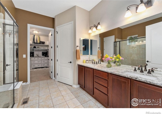 2038 Vineyard Dr, Windsor, CO 80550 - full bath with a shower stall, double vanity, tile patterned floors, and a walk in closet
