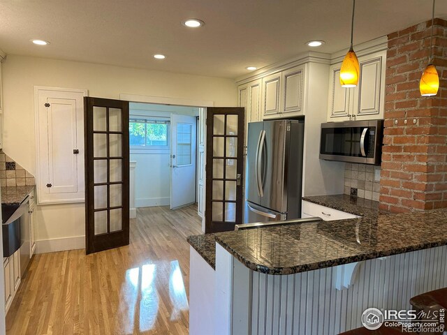 515 Cowan St, Fort Collins, CO 80524 - kitchen featuring stainless steel appliances, french doors, light wood-style flooring, a peninsula, and decorative light fixtures