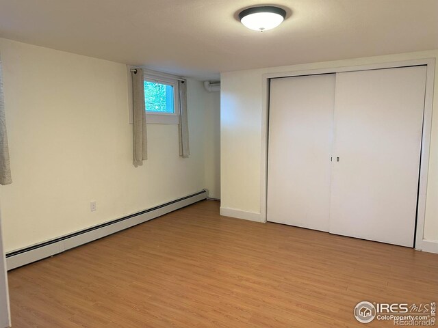 515 Cowan St, Fort Collins, CO 80524 - unfurnished bedroom with a baseboard radiator, light wood finished floors, a closet, and baseboards
