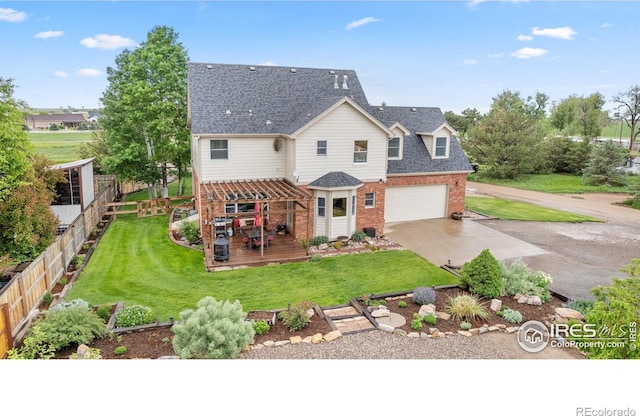 36091 Appy Rd, Eaton, CO 80615 - view of front facade with a wooden deck, driveway, a shingled roof, brick siding, and an attached garage