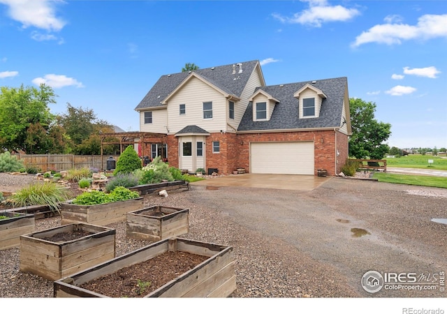 36091 Appy Rd, Eaton, CO 80615 - view of front of house with driveway, brick siding, a vegetable garden, and roof with shingles