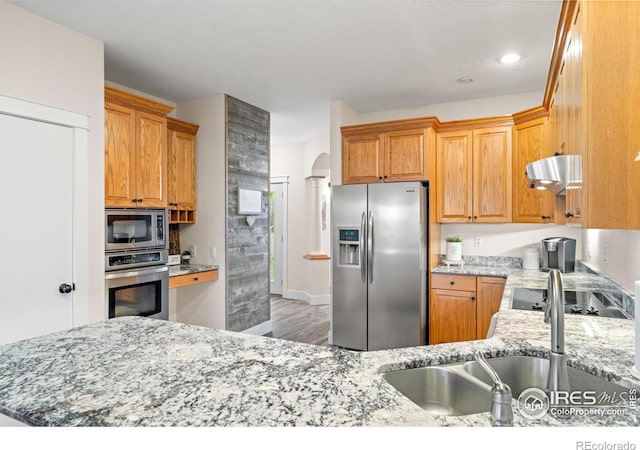 36091 Appy Rd, Eaton, CO 80615 - kitchen with appliances with stainless steel finishes, a sink, light wood-style floors, range hood, and light stone countertops