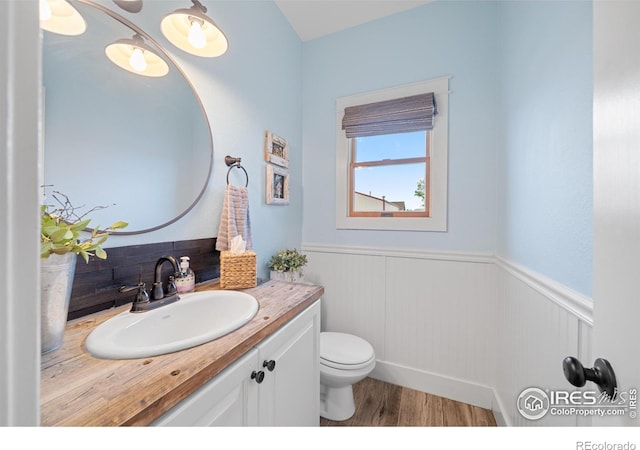 36091 Appy Rd, Eaton, CO 80615 - half bath with toilet, a wainscoted wall, vanity, and wood finished floors