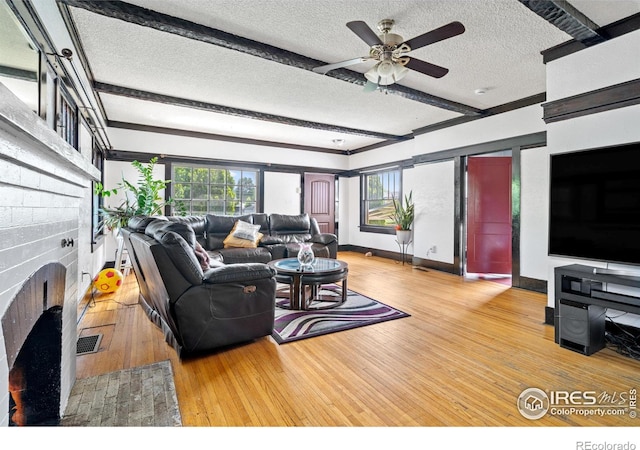 1805 8th St, Greeley, CO 80631 - living area featuring a textured ceiling, hardwood / wood-style flooring, a fireplace, baseboards, and ceiling fan