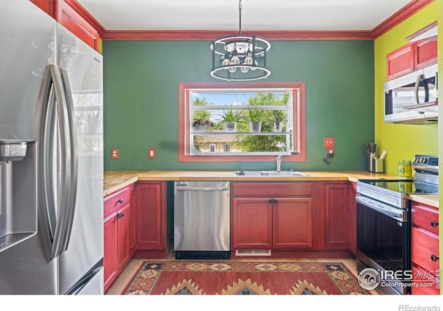 1805 8th St, Greeley, CO 80631 - kitchen featuring stainless steel appliances, a sink, ornamental molding, a chandelier, and reddish brown cabinets