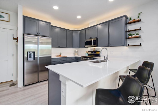 1922 Naturita St, Loveland, CO 80538 - kitchen with stainless steel appliances, a peninsula, a kitchen breakfast bar, light countertops, and recessed lighting