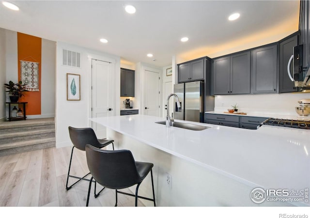 1922 Naturita St, Loveland, CO 80538 - kitchen with a sink, appliances with stainless steel finishes, a kitchen bar, a peninsula, and recessed lighting