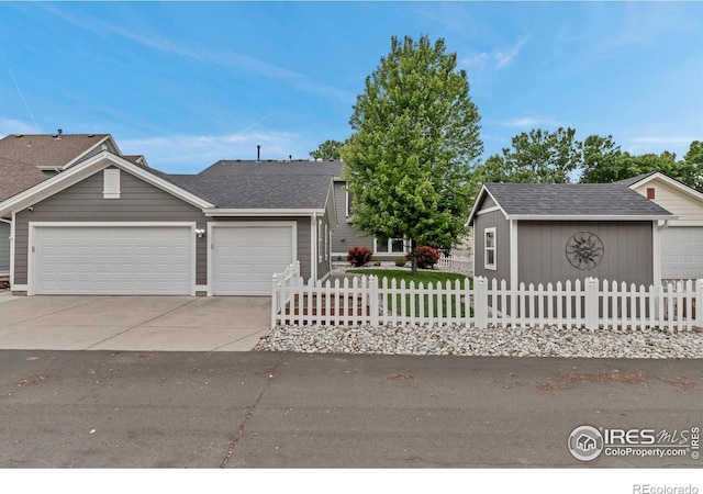 5111 Mt St Vrain Ave, Frederick, CO 80504 - view of front of home with a garage, a fenced front yard, concrete driveway, and a shingled roof