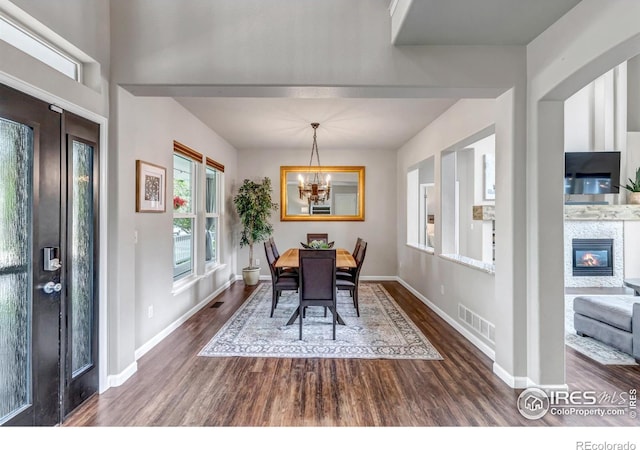 5111 Mt St Vrain Ave, Frederick, CO 80504 - dining space with a chandelier, dark wood finished floors, baseboards, and a glass covered fireplace