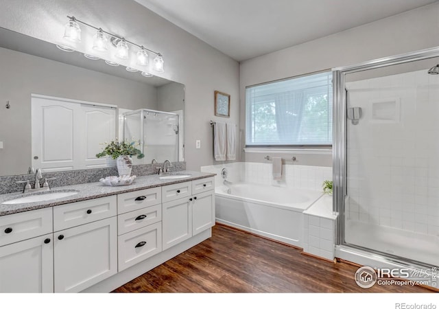 5111 Mt St Vrain Ave, Frederick, CO 80504 - full bathroom featuring a stall shower, a garden tub, double vanity, and wood finished floors