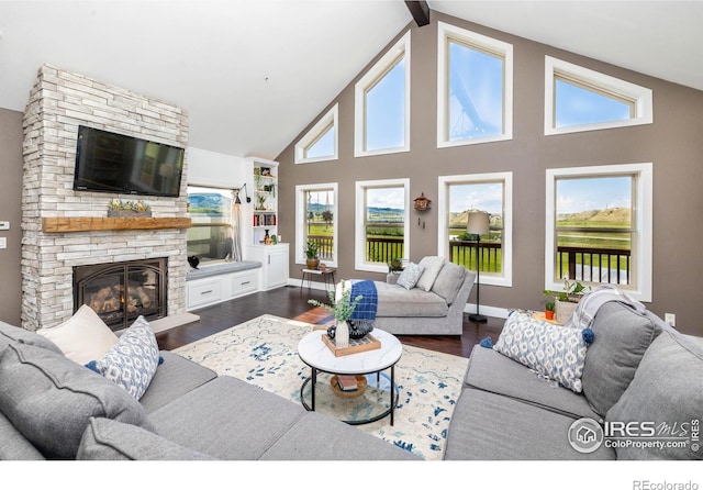 4721 Arthur Mae Ln, Laporte, CO 80535 - living room with dark wood-style floors, healthy amount of natural light, a fireplace, high vaulted ceiling, and beam ceiling