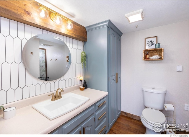 4721 Arthur Mae Ln, Laporte, CO 80535 - bathroom with vanity, wood finished floors, toilet, and backsplash