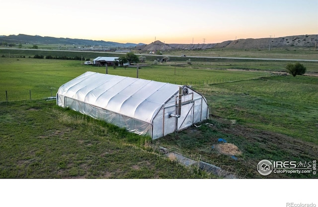 4721 Arthur Mae Ln, Laporte, CO 80535 - outdoor structure at dusk with a greenhouse, a rural view, a lawn, and a mountain view