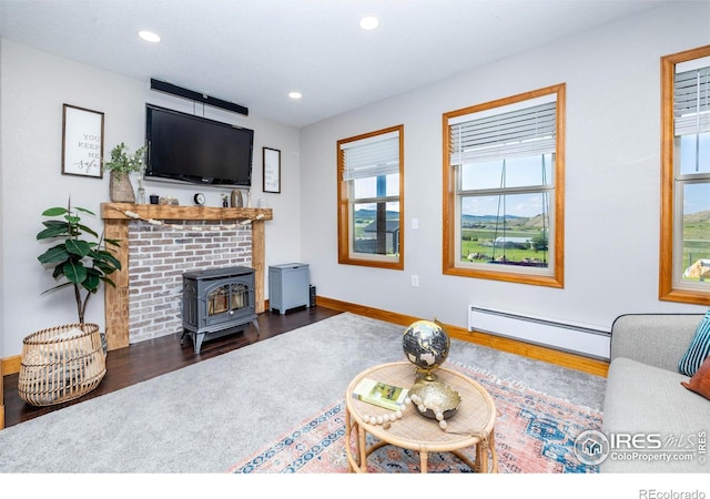 4721 Arthur Mae Ln, Laporte, CO 80535 - living room featuring baseboard heating, a wood stove, wood finished floors, recessed lighting, and baseboards