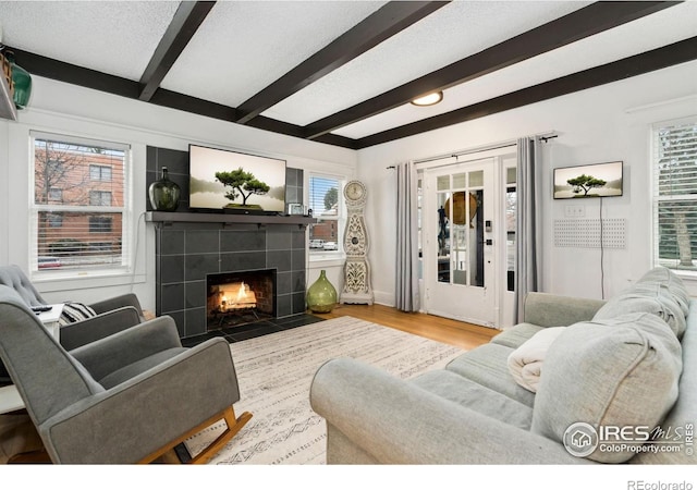 701 Mathews St, Fort Collins, CO 80524 - living area featuring beam ceiling, wood finished floors, and a tile fireplace